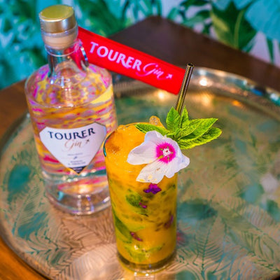 Tourer mango gin and mango mojito cocktail with hibiscus flower garnish 